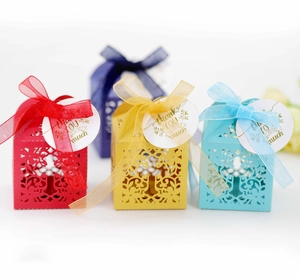 Laser-cut wedding favor boxes with colorful hollow floral patterns and ribbon bows