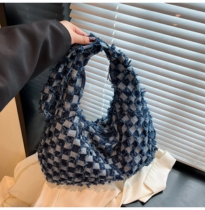 Close-up of retro checkerboard denim hobo tote with distressed raw edge craftsmanship