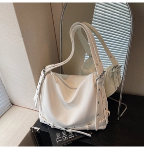 Close-up of white pebbled leather hobo bag with silver rivets and metal hardware