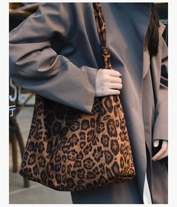 Détail du sac cabas léopard avec poignée nouée porté avec un trench-coat gris