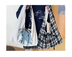Detail view of canvas tote bags with blue elephant print and vintage checkerboard patterns