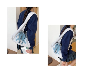 Detail of canvas tote bag with light blue elephant print and checkered bow accent