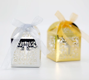 Detailed view of laser-cut cross pattern on silver and gold wedding favor gift boxes