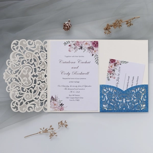 Detailed laser-cut wedding invitation set with floral inserts and blue glitter pocket