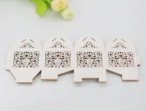 Flat lay of laser-cut wedding favor box with intricate cross and vine hollow patterns