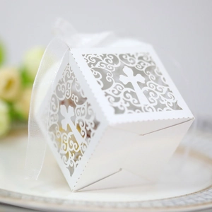 Laser-cut white cross favor box with decorative ribbon for weddings and baptisms