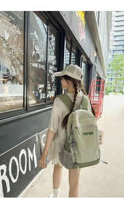 Detail view of a mint green casual backpack featuring side water bottle pocket and brand logo