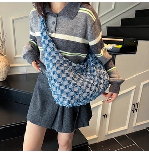 Detailed shot of frayed edges on a blue and white checkered denim tote bag for women