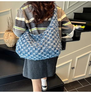 Detail of frayed blue and white checkered denim tote bag with textured frayed edges