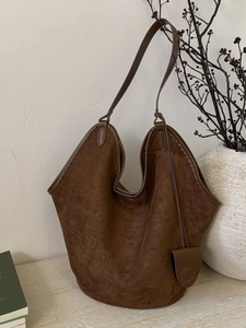 Brown suede hobo shoulder bag with a slouchy silhouette and matching leather charm