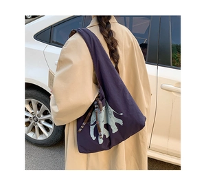 Detail view of large purple canvas tote bag with elephant print and plaid ribbon bow