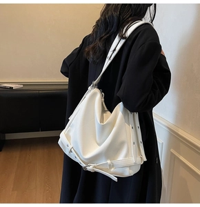 Close-up of white oversized tote bag with lychee grain texture and wide shoulder strap