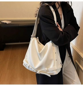 Detailed macro view of white pebbled leather tote bag with metal eyelet strap detail