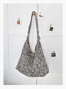 Détail du sac cabas en toile à motif léopard avec une bandoulière nouée élégante et moderne
