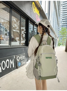 Detail of green two-tone backpack featuring adjustable straps and durable mesh side pockets