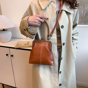 Close-up of retro orange-brown leather doctor bag with kiss-lock and white stitching