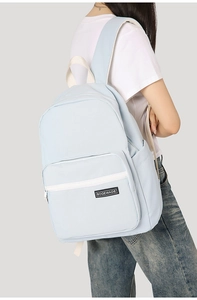 Light blue minimalist backpack featuring large main compartment and front zipper pocket