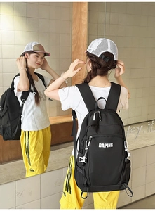 Detail view of black travel backpack featuring white lettering and adjustable buckles