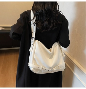 Detail of white lychee-patterned tote bag with wide shoulder strap and silver eyelets