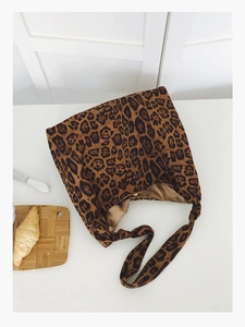 Vue détaillée de dessus d'un sac cabas imprimé léopard à côté d'un croissant et couteau