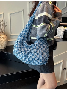 Vintage checkered denim tote bag with frayed edge texture and wide shoulder strap