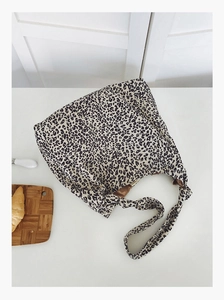 Vue macro à plat du sac cabas en toile à imprimé léopard avec une doublure en tissu de qualité