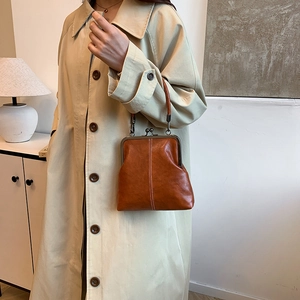 Detail of vintage brown leather doctor bag with bronze metal clasp and rounded handle