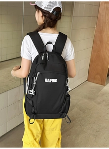 Close-up of black waterproof nylon backpack with white logo and adjustable chest buckle