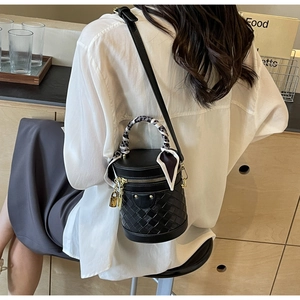 Black woven leather bucket bag with silk scarf handle and elegant gold lock detail