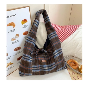 Detail of checkered tote bag with woven fabric texture and knot decoration detail