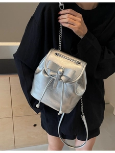 Silver metallic backpack with bow detail and chain straps for a modern chic look