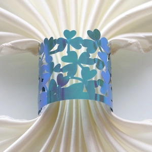 Dettaglio portatovagliolo a forma di cuore con finitura blu metallizzata iridescente