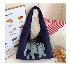 Detail of navy canvas tote bag featuring a blue elephant print and checkered drawstring top