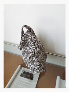 Détail d'un sac à main à motif léopard noir et blanc sur une table en verre moderne