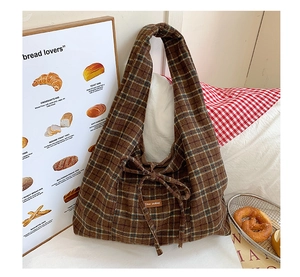 Detail of vintage brown plaid tote bag with decorative bow and Slow Picking label