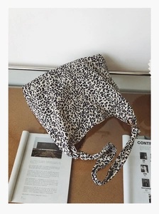 Gros plan du sac cabas en toile léopard avec détail de la bandoulière nouée élégante