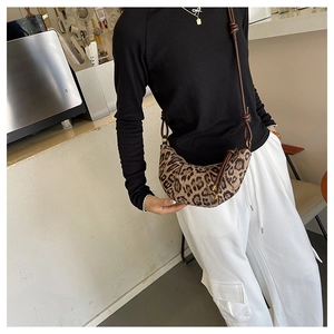 Borsa a tracolla a mezzaluna leopardata indossata con un outfit moderno alla moda