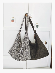 Détail de grands sacs cabas en toile à imprimé léopard en beige et vert olive