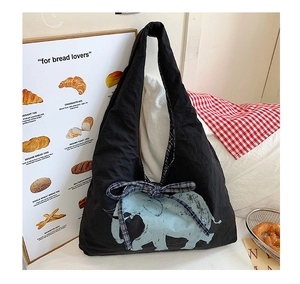 Detail of canvas tote bag featuring blue elephant print and checkered bow decoration