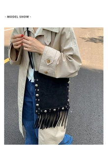 Detailed view of black studded crossbody bag with fringe tassels on female model