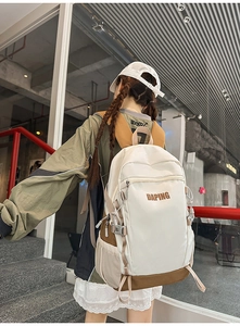 Detailed back view of a large-capacity white and brown backpack with multiple pockets