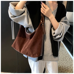Détail du grand sac hobo en daim marron foncé avec bordures en cuir et étiquette