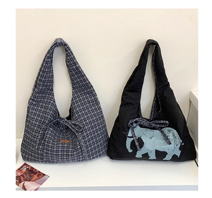 Detail of canvas tote bags featuring classic plaid and elephant prints with bow drawstrings
