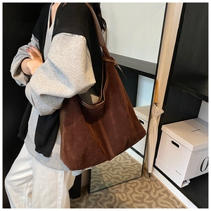 Détail du sac cabas en daim marron foncé montrant la silhouette hobo et la texture