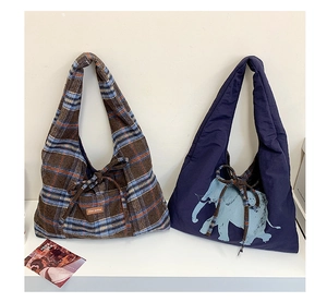 Detailed view of the plaid wool tote and the navy fabric bag with an elephant print