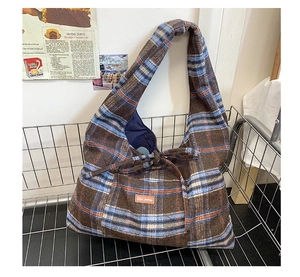 Detail of retro plaid tote bag made of thick wool fabric inside a vintage metal basket