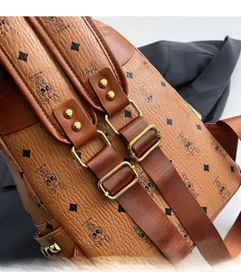 Detail of adjustable nylon shoulder strap with gold metal buckle on brown backpack