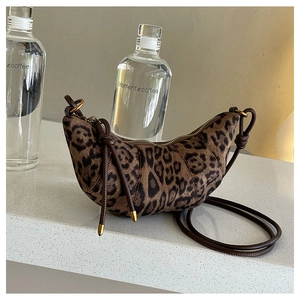 Dettaglio borsa a mezzaluna leopardata con tracolla annodata e finiture in oro