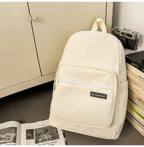 Detail of minimalist beige backpack with zipper pocket on a desk with retro camera