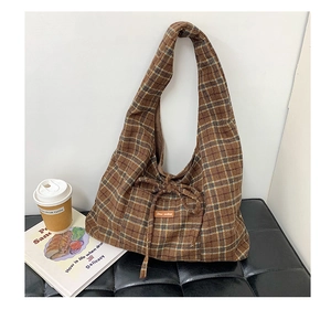 Detailed texture of brown plaid wool fabric with a leather star-picking brand tag